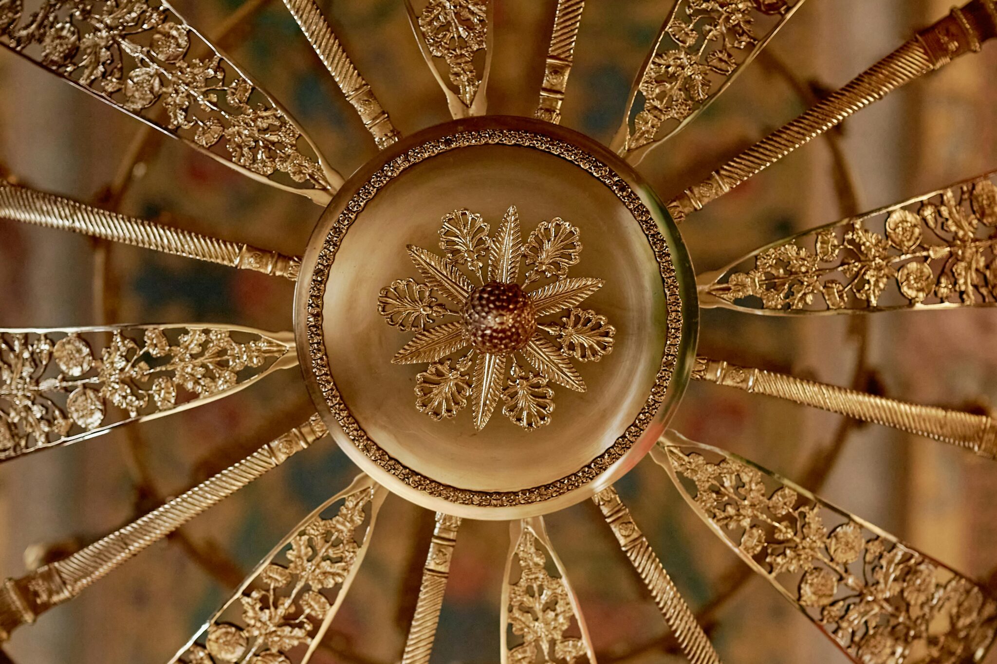 Close-up of an ornate gold floral ceiling medallion showcasing intricate design and decoration.